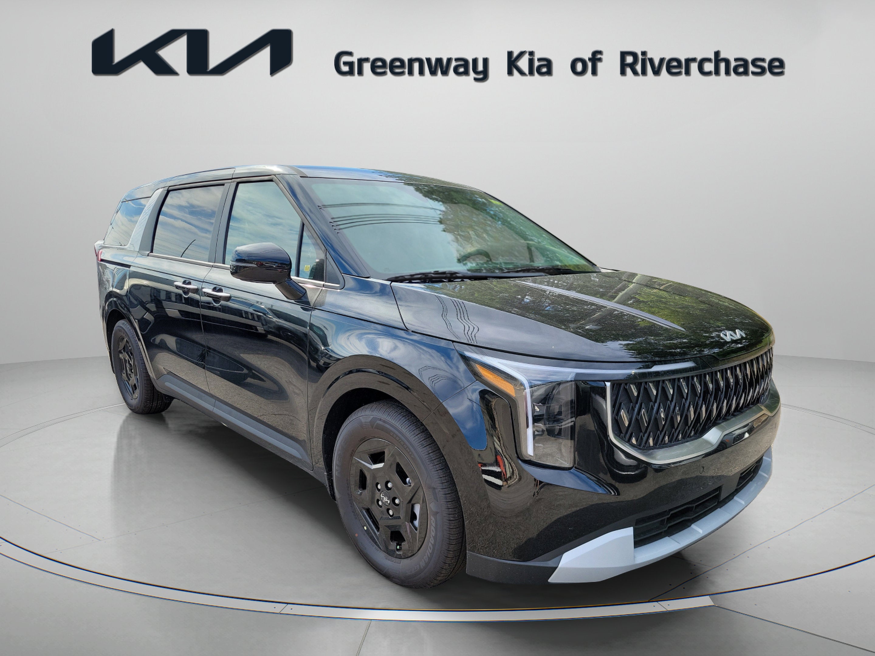 2026 Kia Carnival LXS in Aurora Black Pearl — front three-quarter view